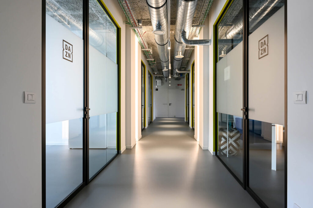 FERVI parete divisoria 6030 corridoio parete vetrata a vetro doppio extra clear con effetto localizzato di privacy visiva e serigrafia personalizzata profilo in alluminio pure black ral 9005 porta a battente