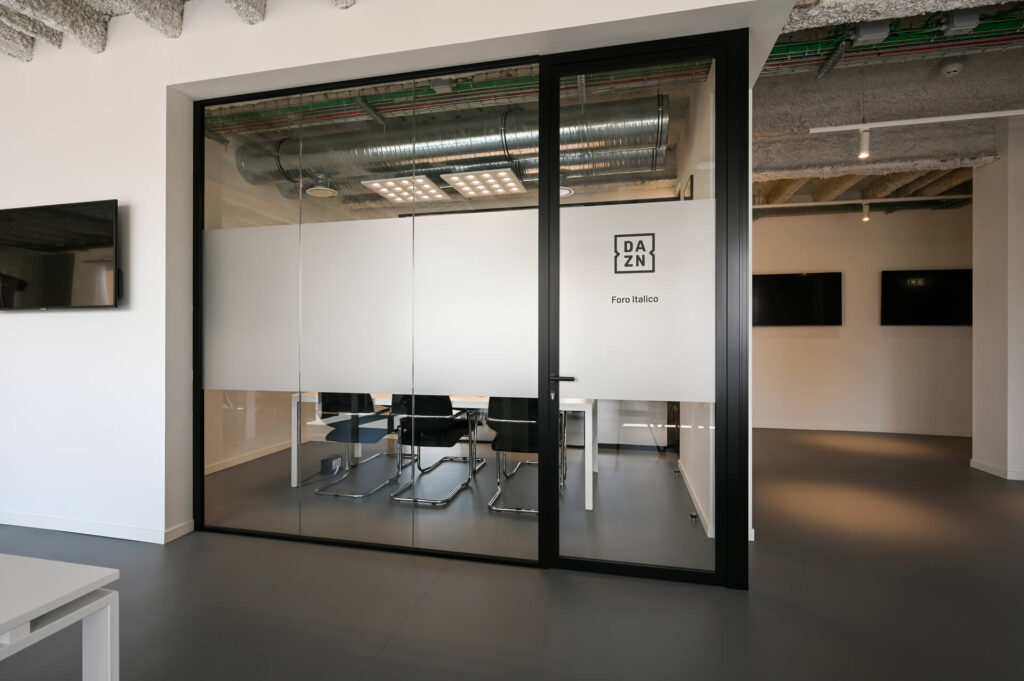 FERVI parete divisoria 6030 sala riunione parete vetrata a vetro doppio extra clear con effetto localizzato di privacy visiva e serigrafia personalizzata profilo in alluminio pure black ral 9005 porta a battente
