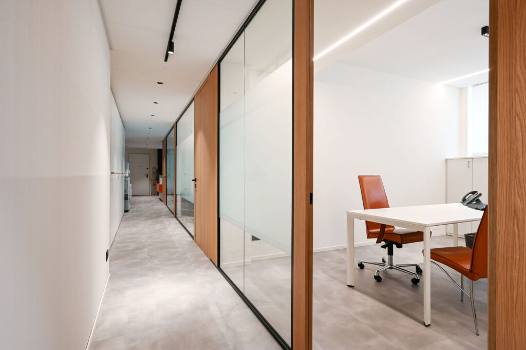 EPICA parete divisoria SLIM corridoio pareti vetrate a vetro singolo extra clear con profilo in alluminio jet black ral 9005 e porte a battente con anta cieca in legno colore oak