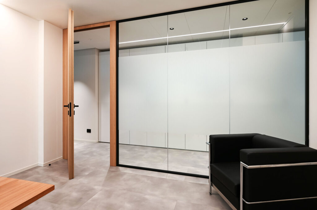 EPICA parete divisoria SLIM ufficio privato pareti vetrate a vetro singolo extra clear con profilo in alluminio jet black ral 9005 e porte a battente con anta cieca in legno colore oak