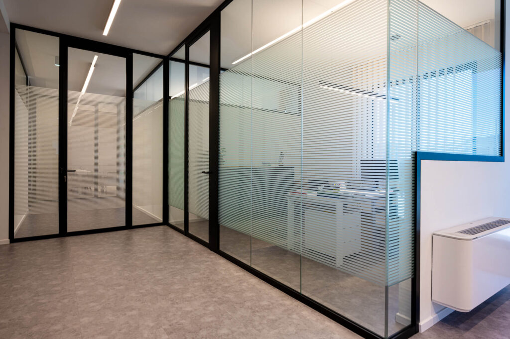 FERRUNION parete divisoria Glass corridoio parete vetrata a vetro singolo extra clear con serigrafia personalizzata per privacy visiva profilo in alluminio black ral 9005 porta a battente con vano tecnico dettaglio angolo giunzione pannelli in vetro