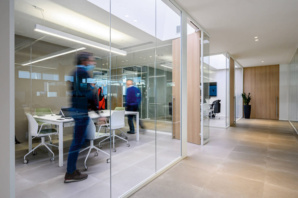 FRIUL INTAGLI INDUSTRIE sala riunione parete divisoria Glass parete vetrata a vetro singolo extra clear profilo in alluminio pure white rat 9010 e porte a battente con anta cieca in legno colore oak