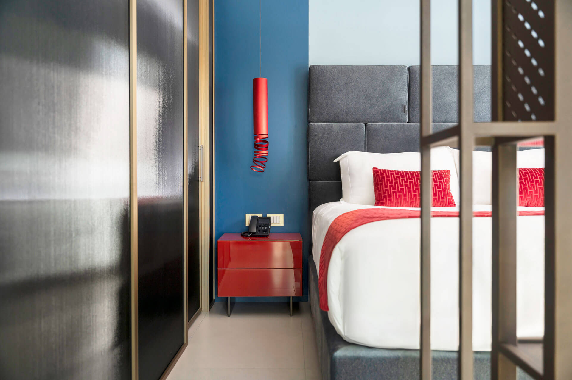 Parete divisoria glass con vetro cannettato fumè, profilo in ottone e porta scorrevole